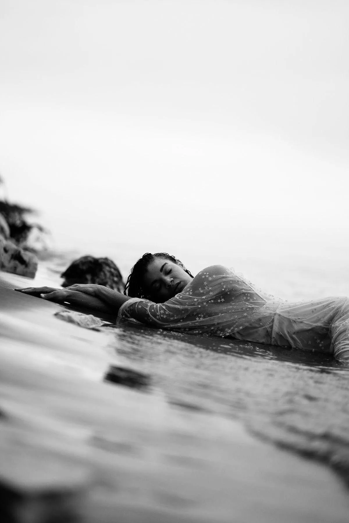 Artistic Black and White Photo of a Woman At the Beach Rocks