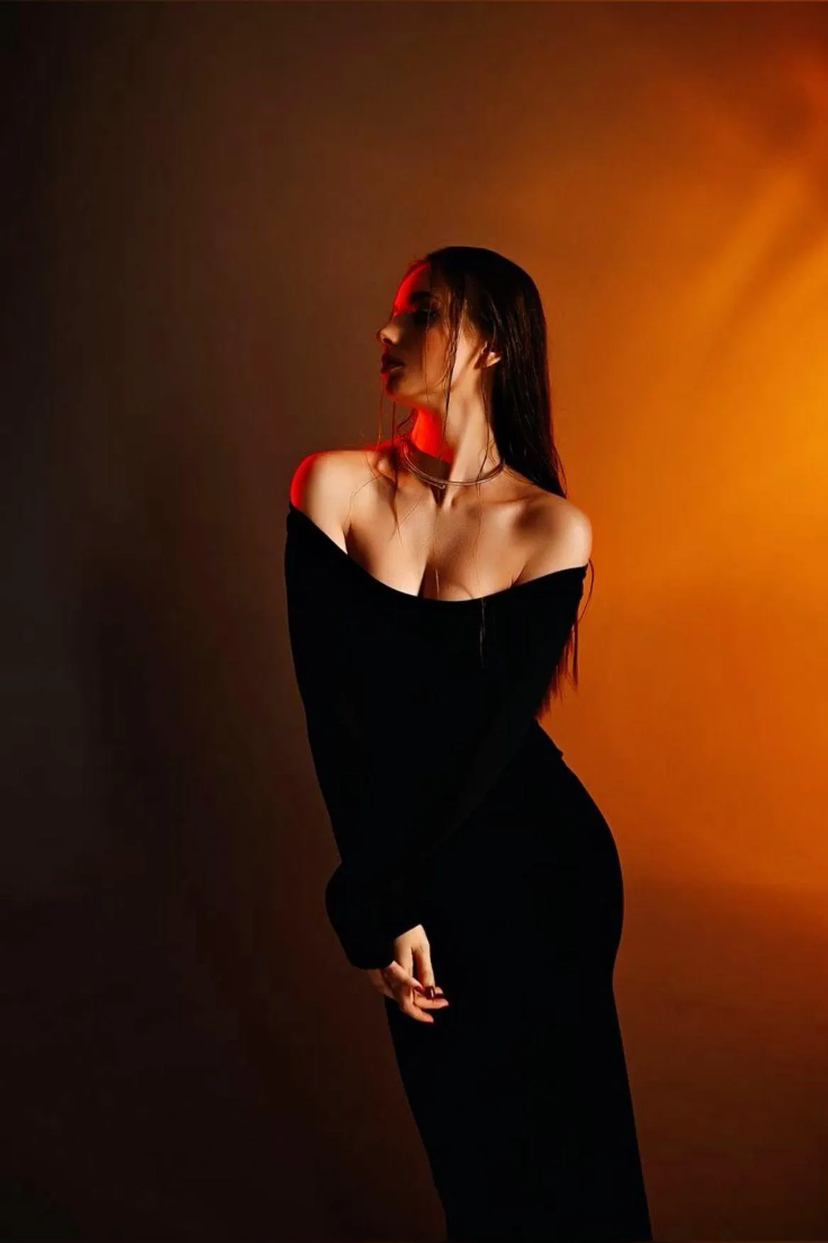 Artistic Photo of a Woman in a Black Dress with Orange Light