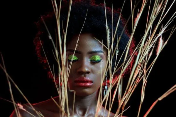 Artistic Portrait of a Woman with Bold Makeup and Dry Grass