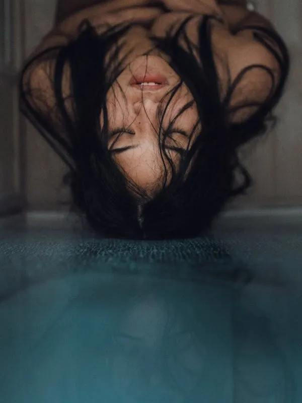 Artistic Top Down Portrait of a Woman Floating in Dark Water