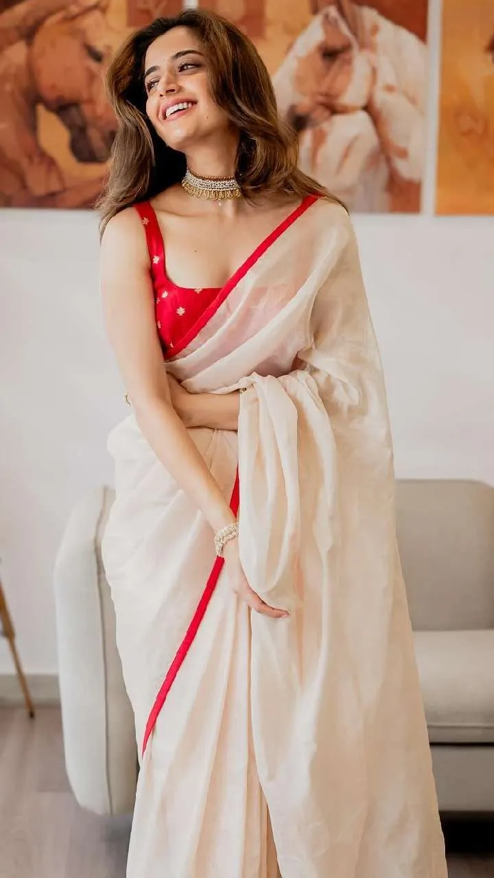 Ashika Ranganath in a saree standing with a smile wallpaper