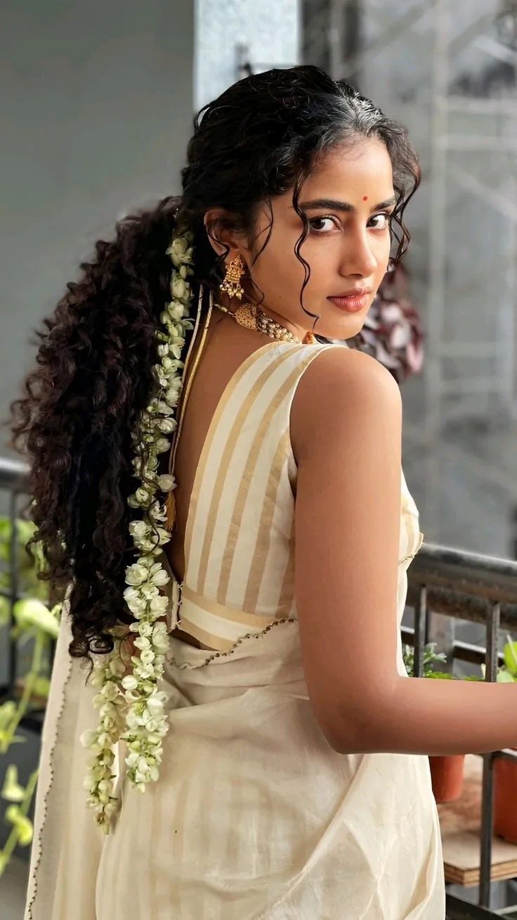 Back view of Anupama Parameswaran in a striped white saree