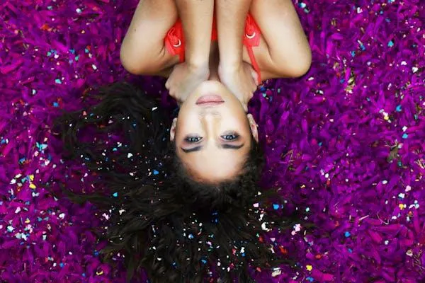 Beautiful Woman Lying on Purple Flowers Looking Straight