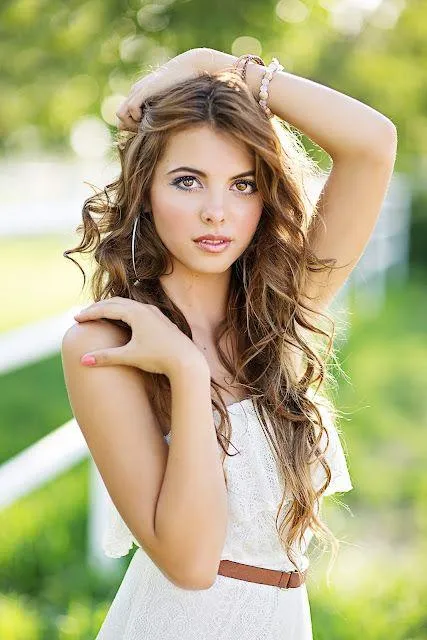 Beautiful Woman in a White Dress Posing Outside in Sunlight