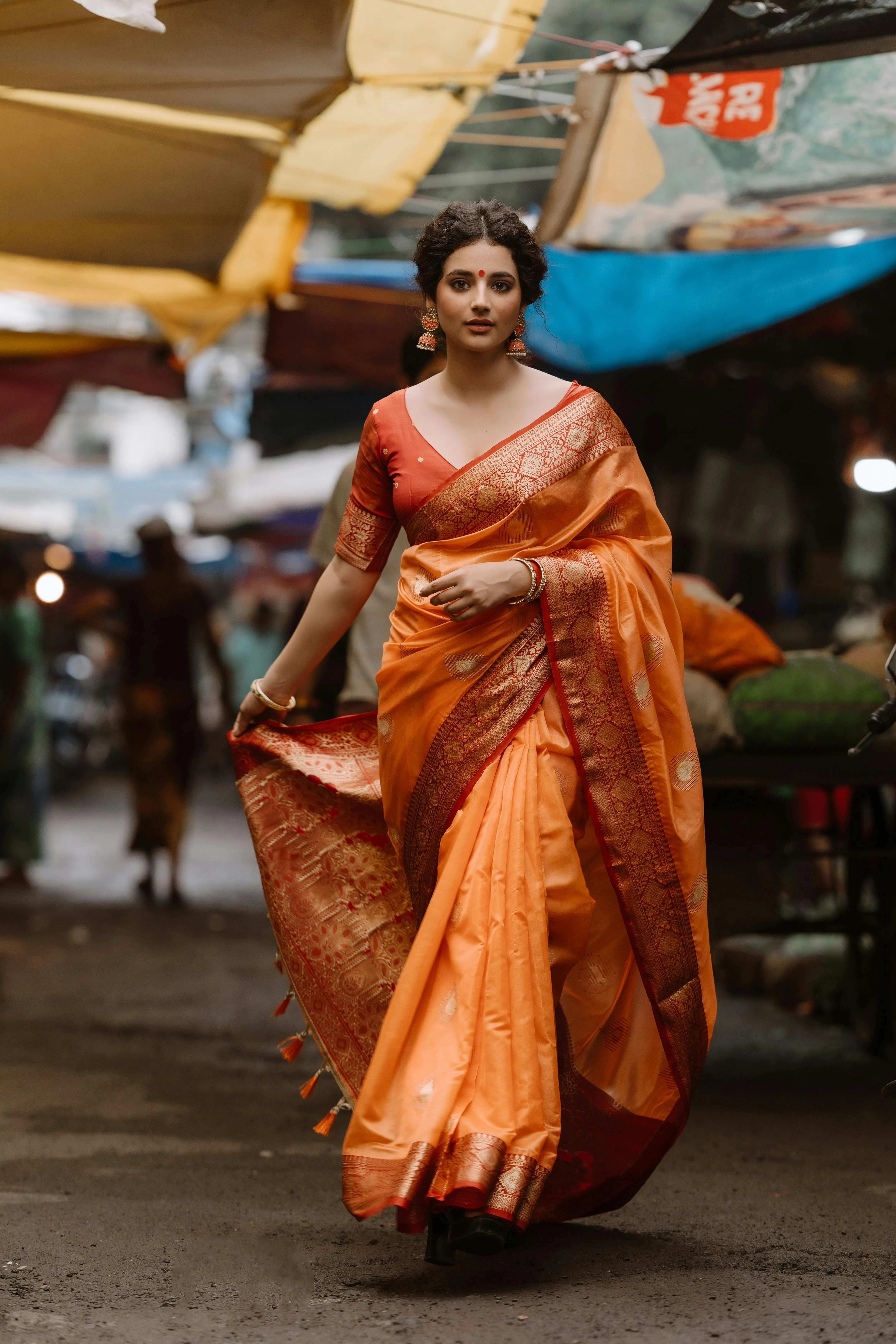 Beautiful Young Woman in Orange Saree Walking Outside Image