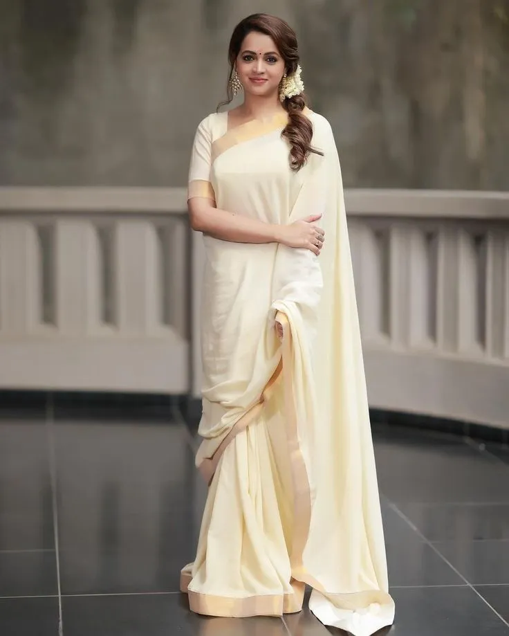 Bhavana in a Kasavu saree standing on the studio floor image