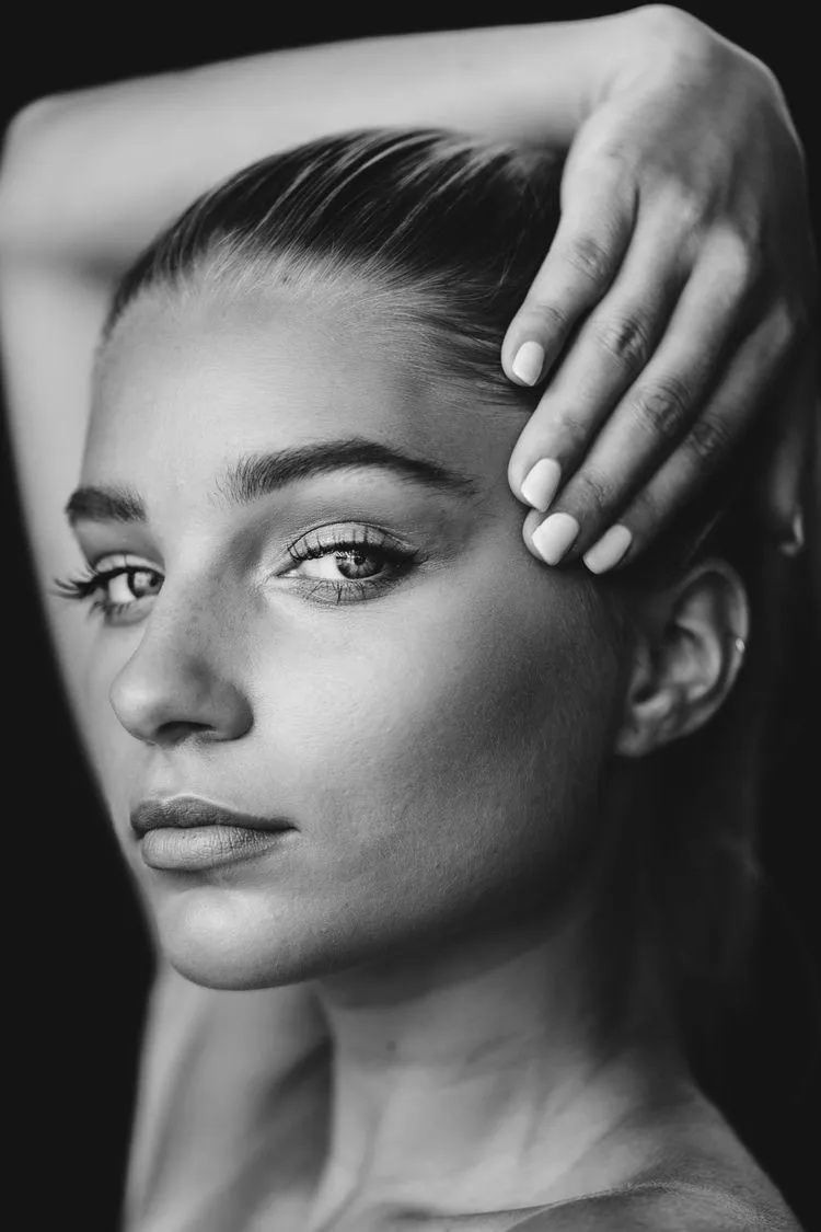 Black and White Close Up Portrait of Woman Touching Her Face