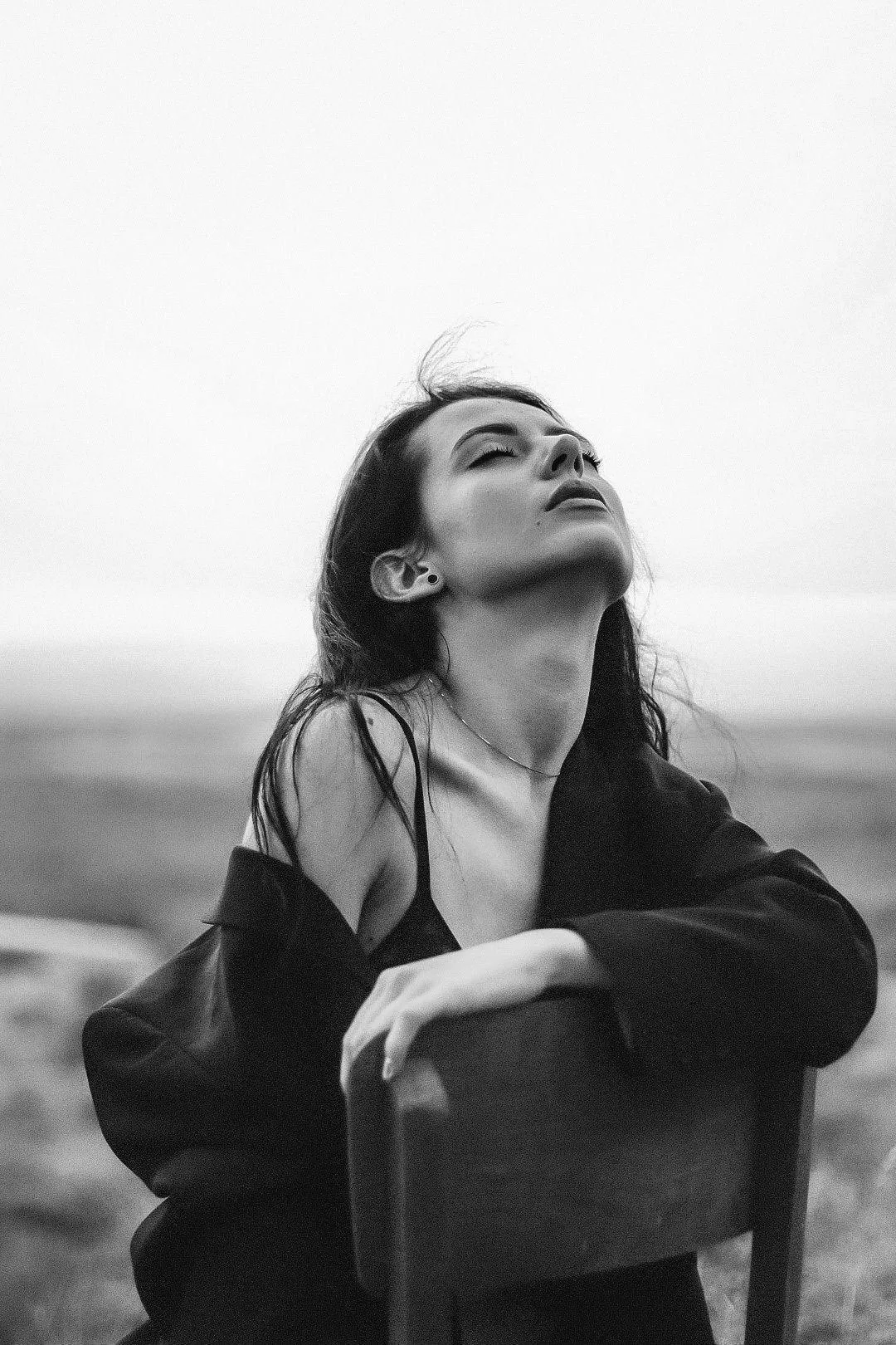 Black and White Image of a Woman Looking Up in Open Jacket
