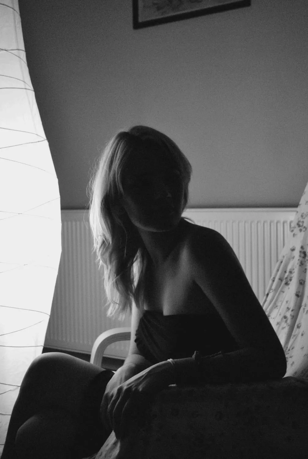 Black and White Image of a Woman Sitting on a Sofa Wallpaper