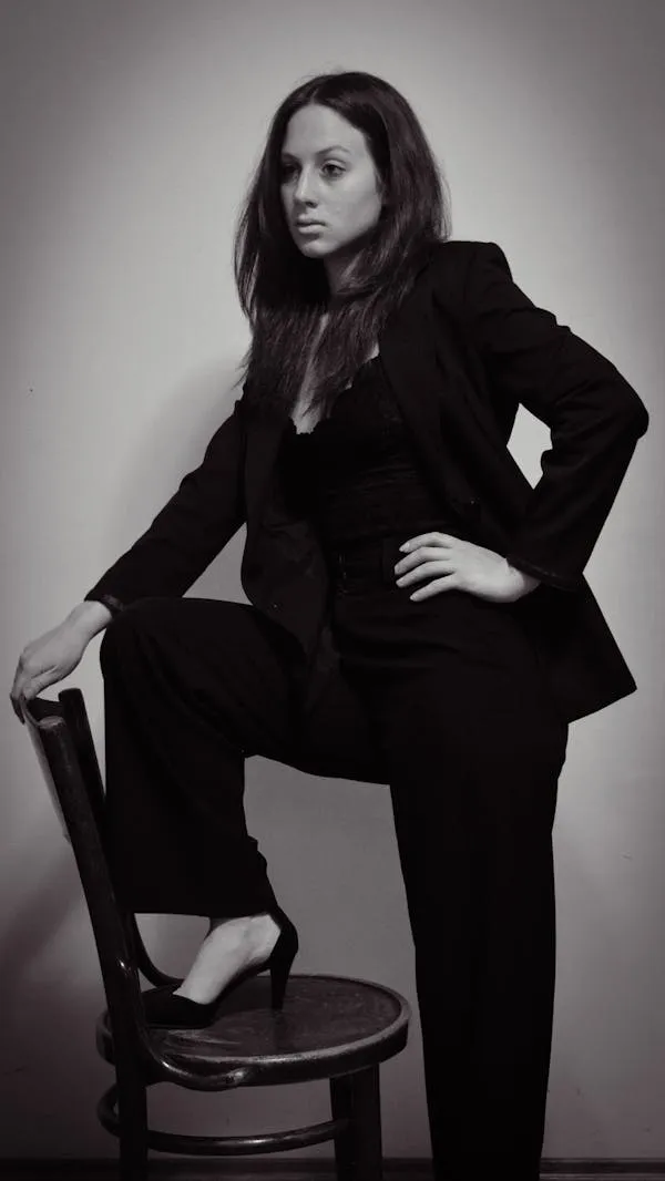 Black and White Photo of Woman Confidently Posing with Chair