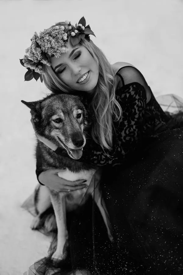 Black and White Photo of a Woman Cuddling with Her Dog Image