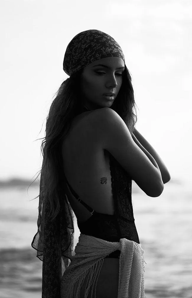 Black and White Photo of a Woman Standing by the Seaside