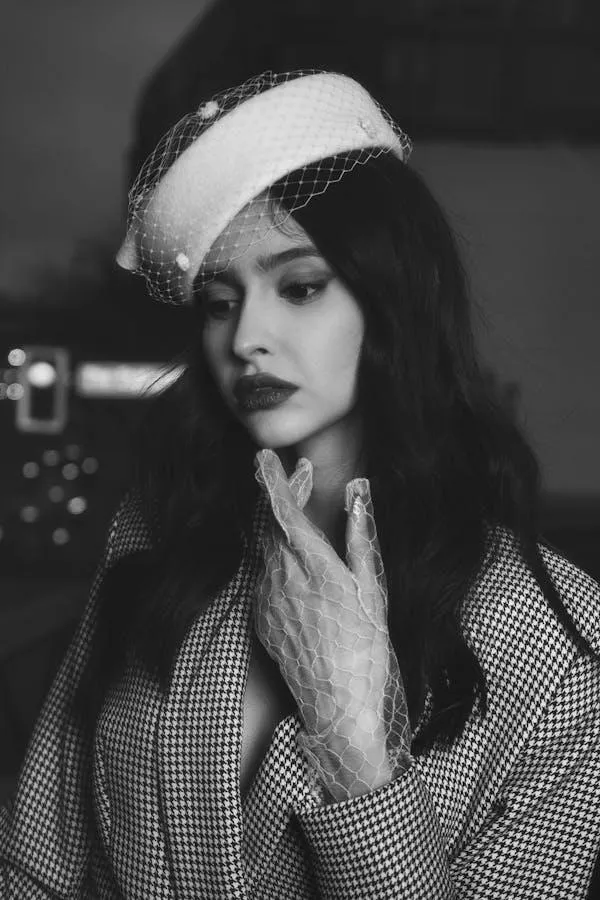 Black and White Photo of a Woman Wearing a Vintage Style Hat