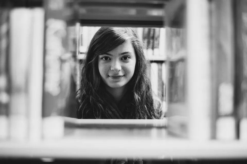 Black and White Portrait of a Smiling Woman At a Window