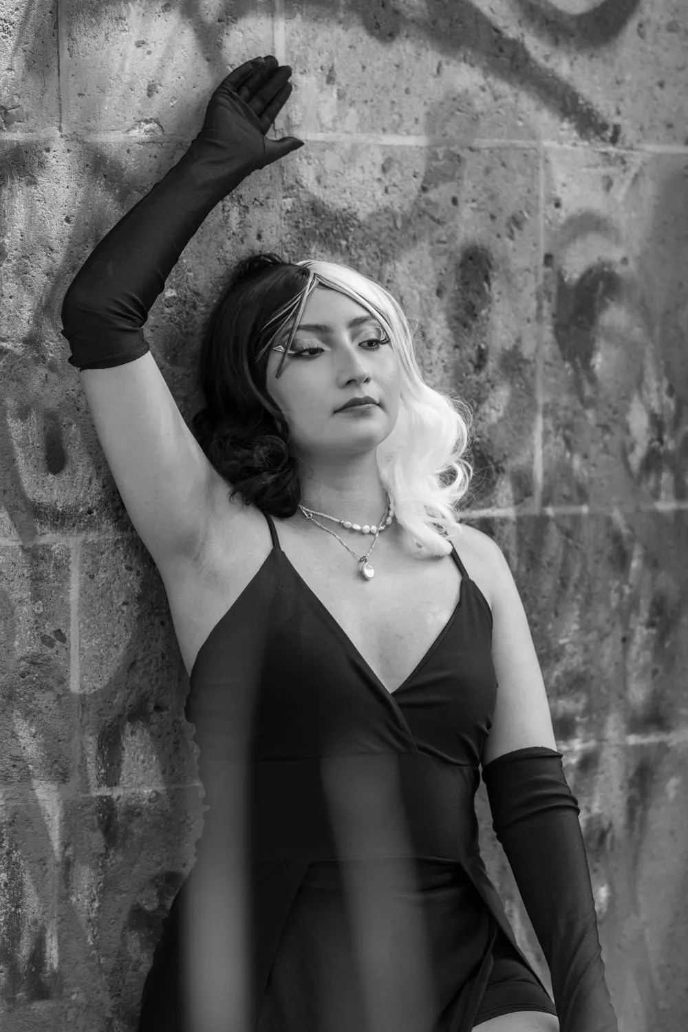 Black and White Woman Posing in Long Gloves by a Stone Wall