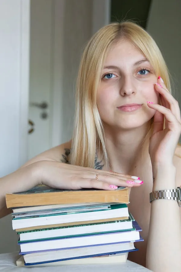 Blonde Girl Resting Face on Hand with a Stack of Textbooks