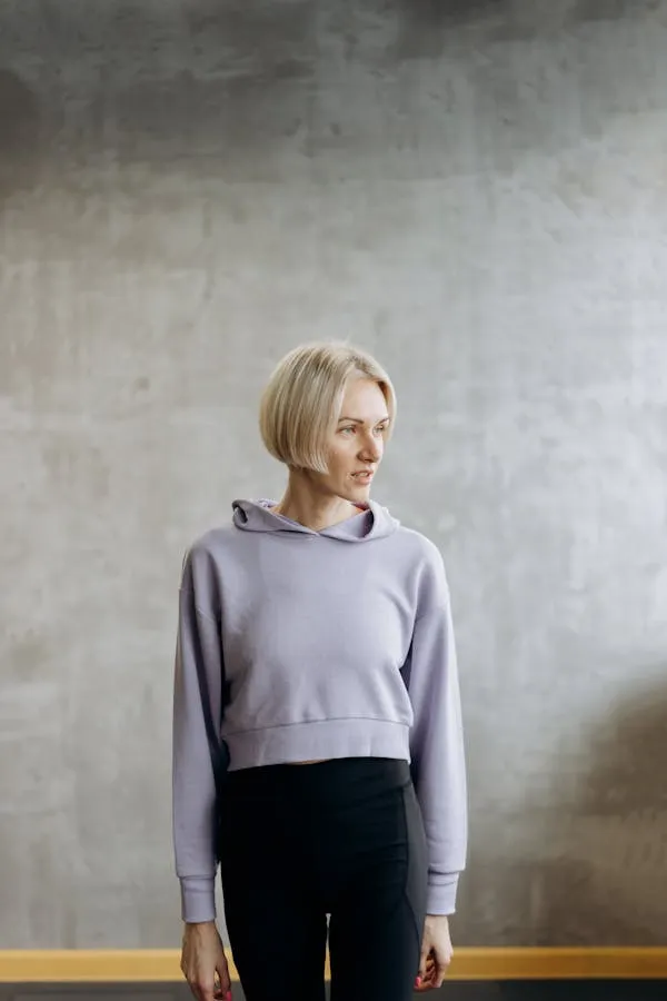 Blonde Woman in Casual Outfit Standing Against Textured Wall