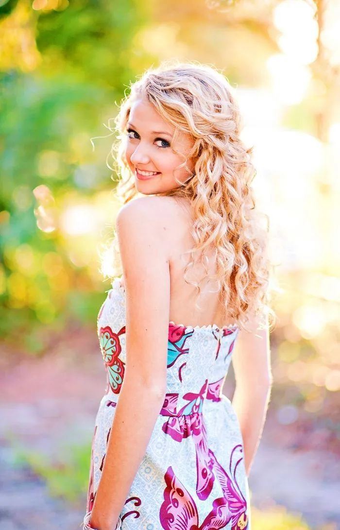 Blonde Woman in a Floral Dress Posing Outdoors in Sunlight
