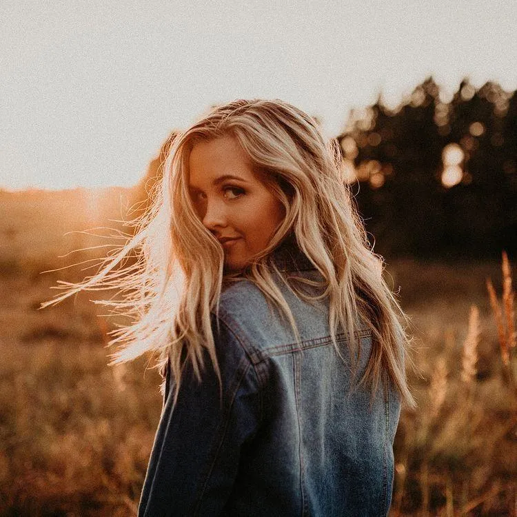Blonde Woman Outdoors with Windblown Hair and a Denim Shirt