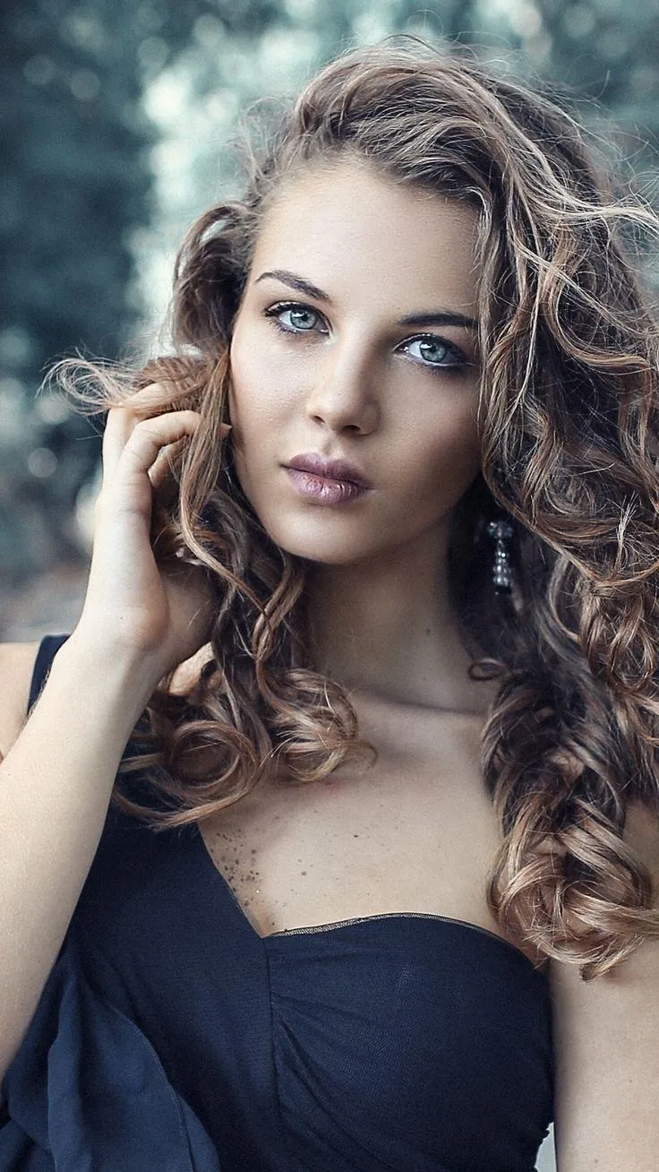 Blonde Woman Sitting on a Custom Motorcycle Near a Building