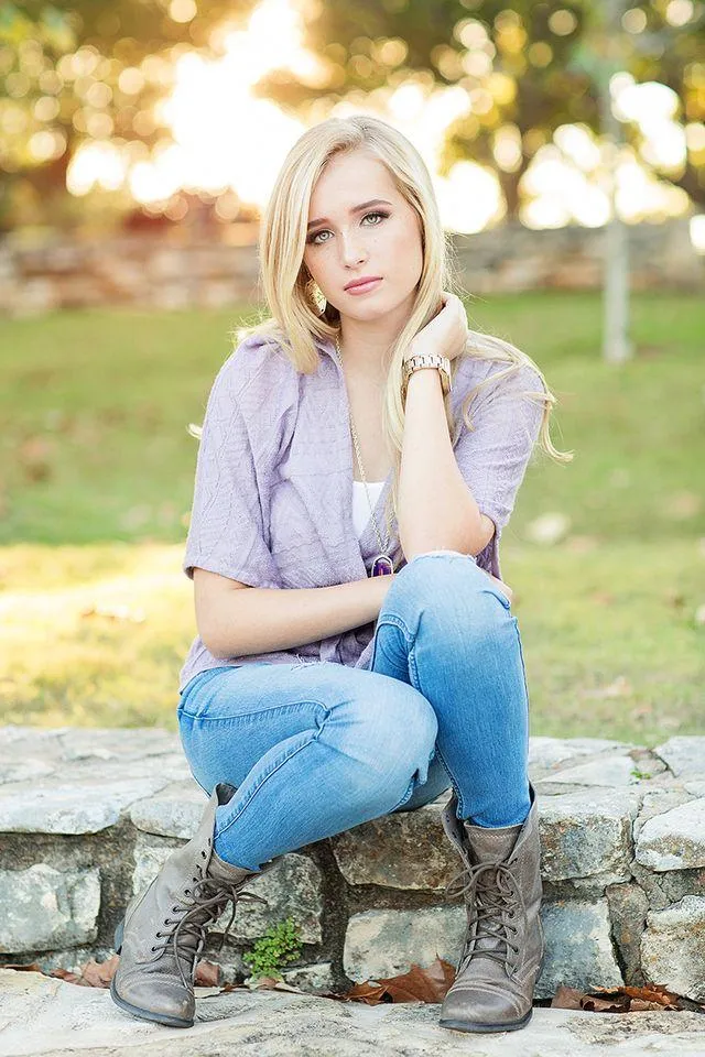 Blonde Woman Sitting on a Stone Bench in a Green Park Image