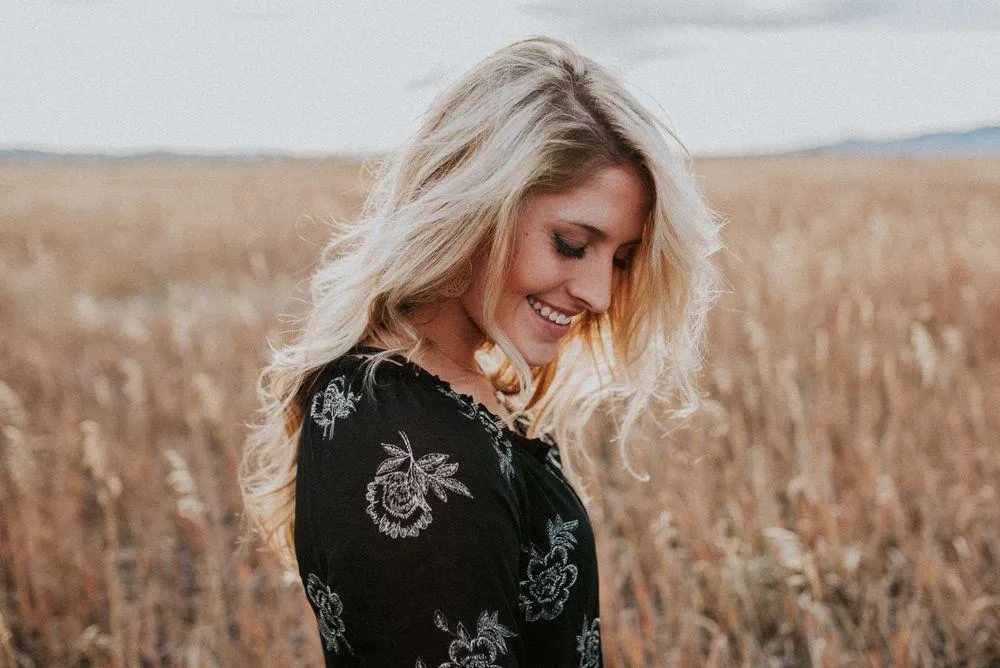 Blonde Woman Smiling in a Field During Golden Hour Wallpaper