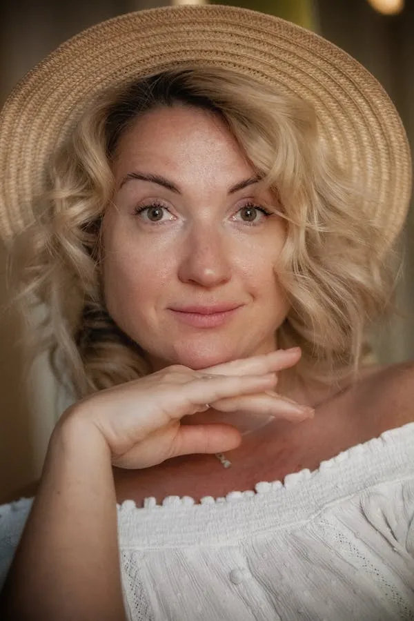 Blonde Woman in Straw Hat and White Off Shoulder Top Smiling