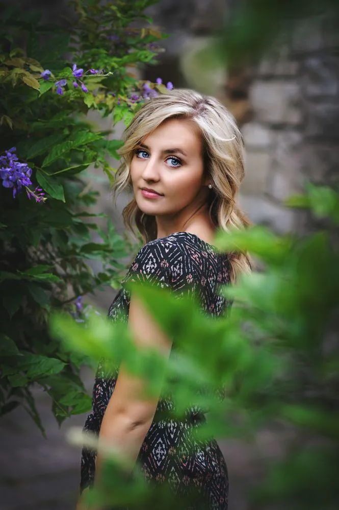 Blonde Woman Surrounded by a White Blossoms in the Garden