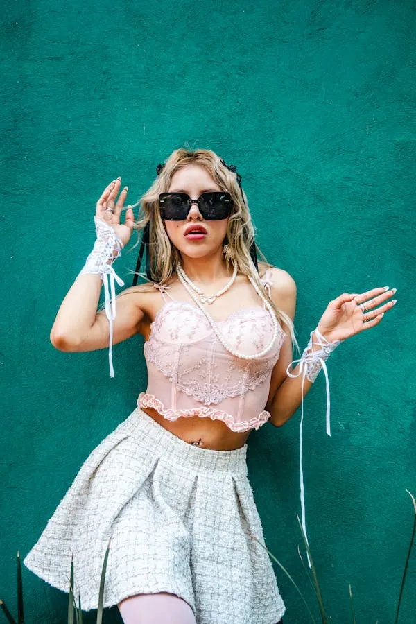 Blonde Woman Wearing Sunglasses Dancing Against a Blue Wall