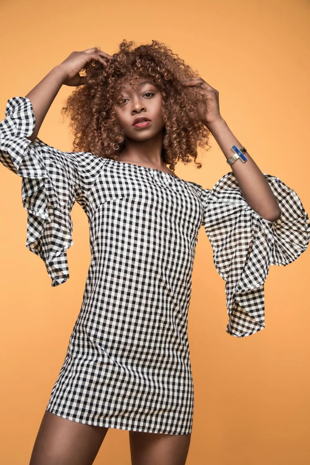Bold Fashion Pose by a Model in a Checkered Dress Indoors