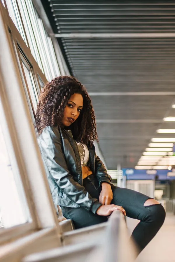 Casual Curly Haired Woman Sitting by Large Window with Light