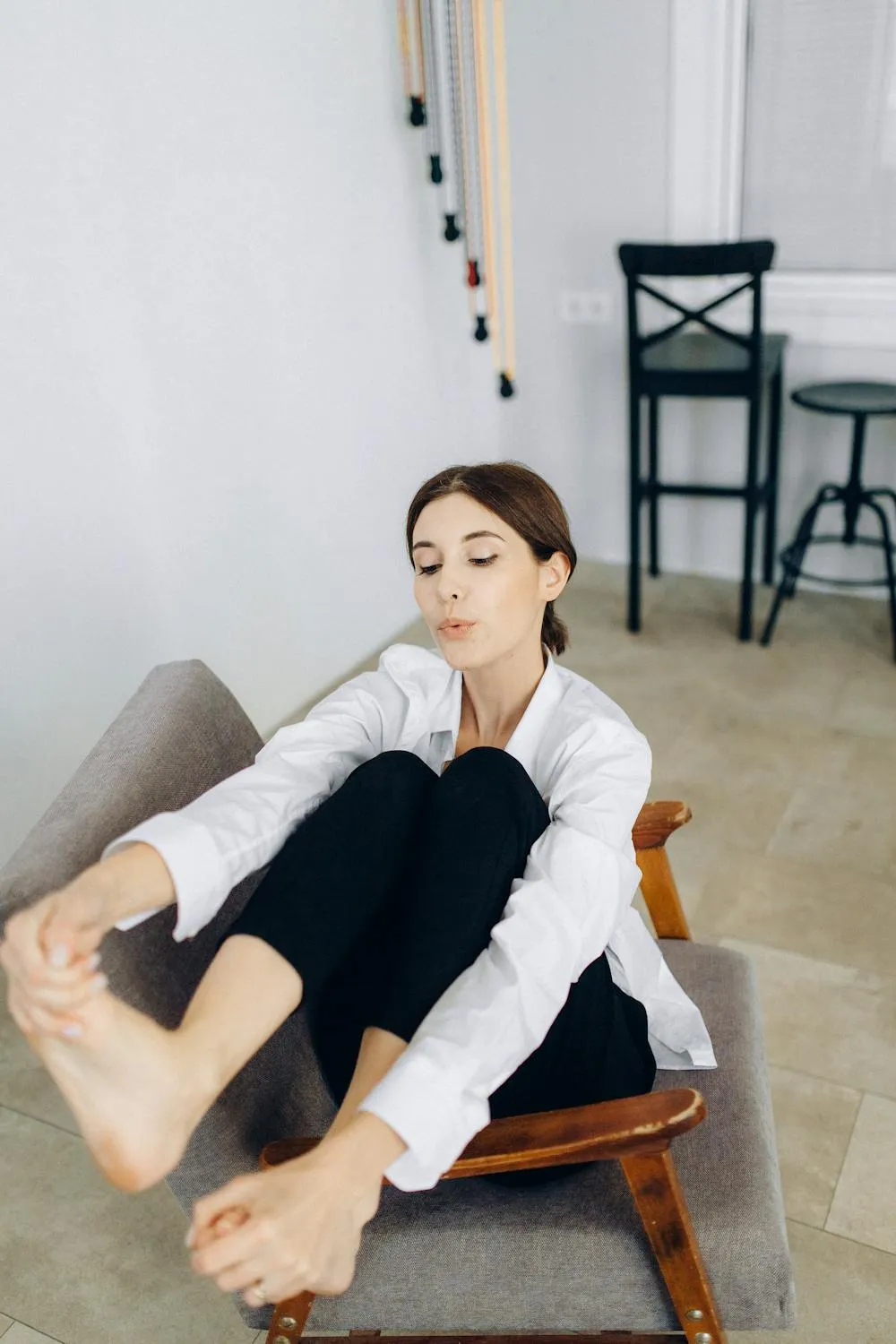 Casual Relaxed Woman Sitting on a Chair in Cozy Modern Room
