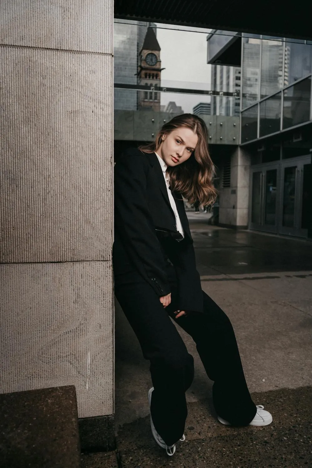 Casual Street Style Woman Leaning Against a Modern Building