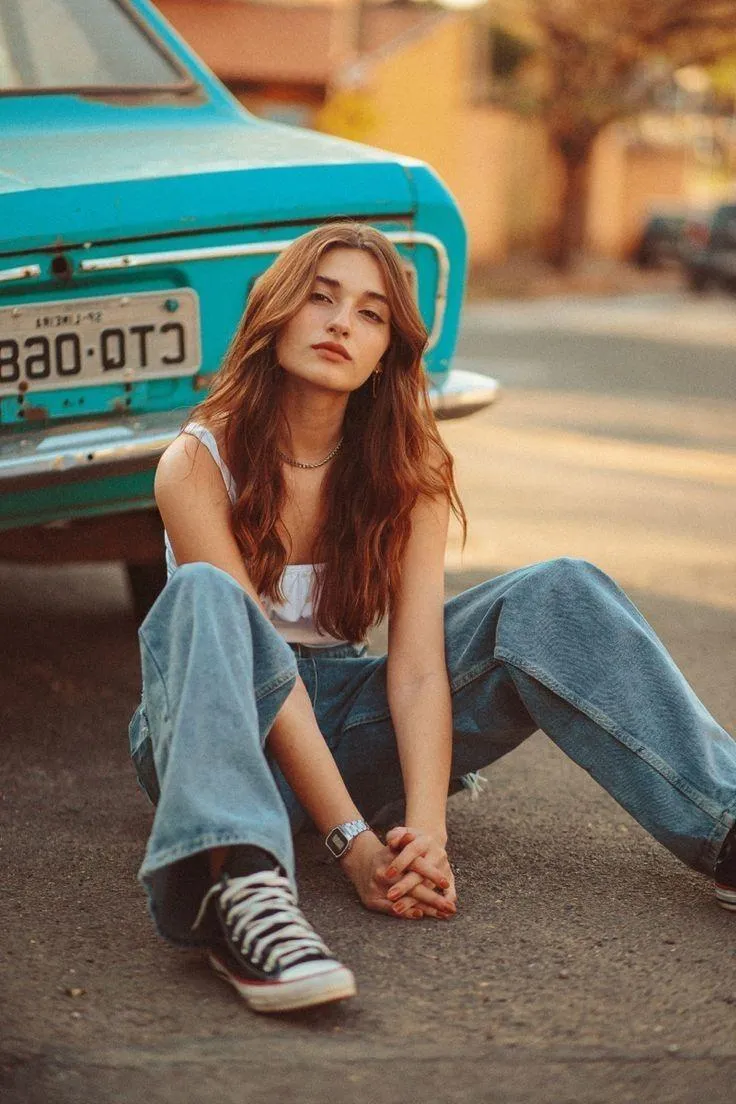 Casual Young Woman Sitting on the Street Near a Vintage Car