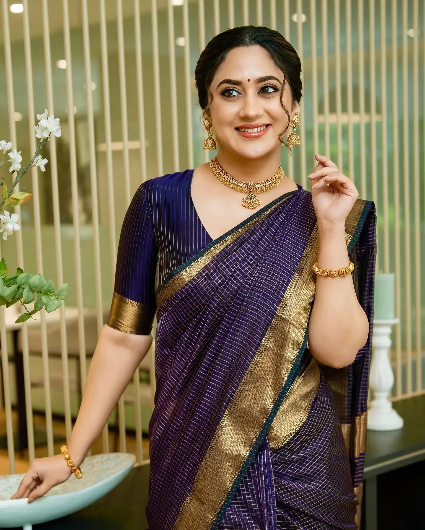 Charming Miya George in Purple Saree Standing Pose Wallpaper