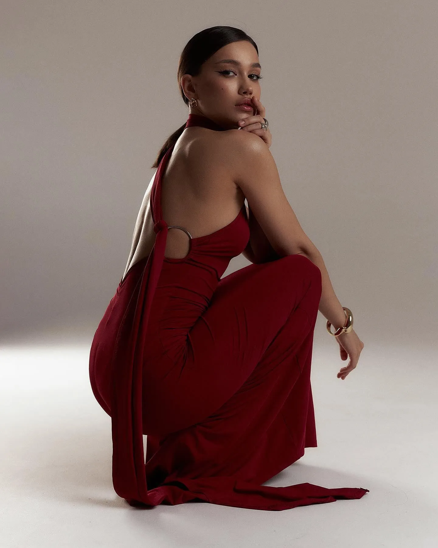 Chic Woman in a Red Outfit Posing on a White Background