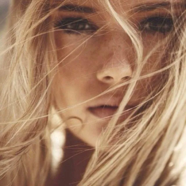 Close Up of Blonde Woman with Hair Blowing in Wind Wallpaper