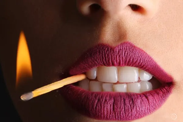 Close Up of Lips Holding a Lit Match Creating a Bold Visual