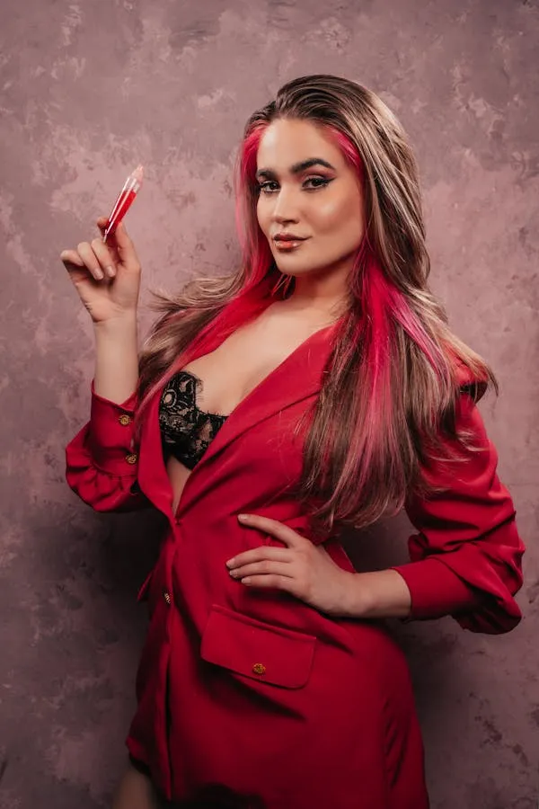 Confident Model Holding Lipstick Wearing a Bold Red Jacket