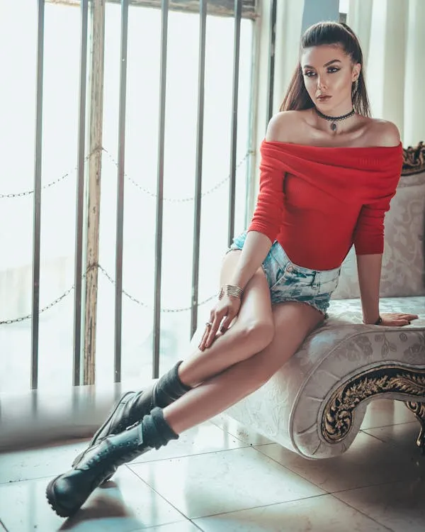 Confident Woman in a Red Top Sitting in a Chic Modern Room