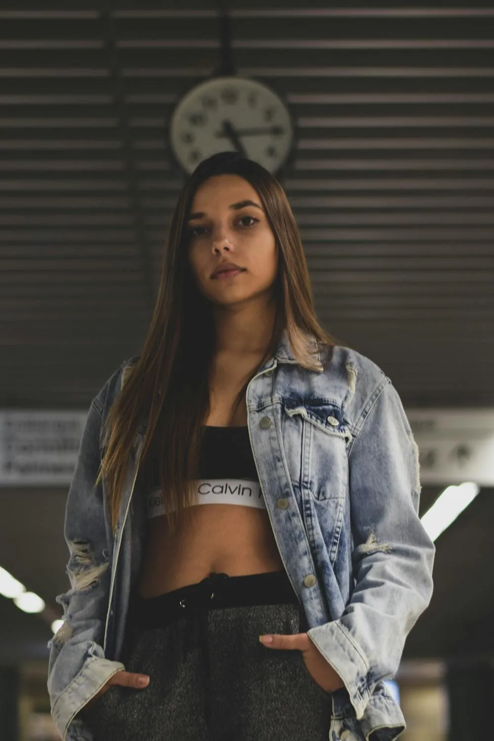Confident Woman Standing Under a Clock in an Urban Setting