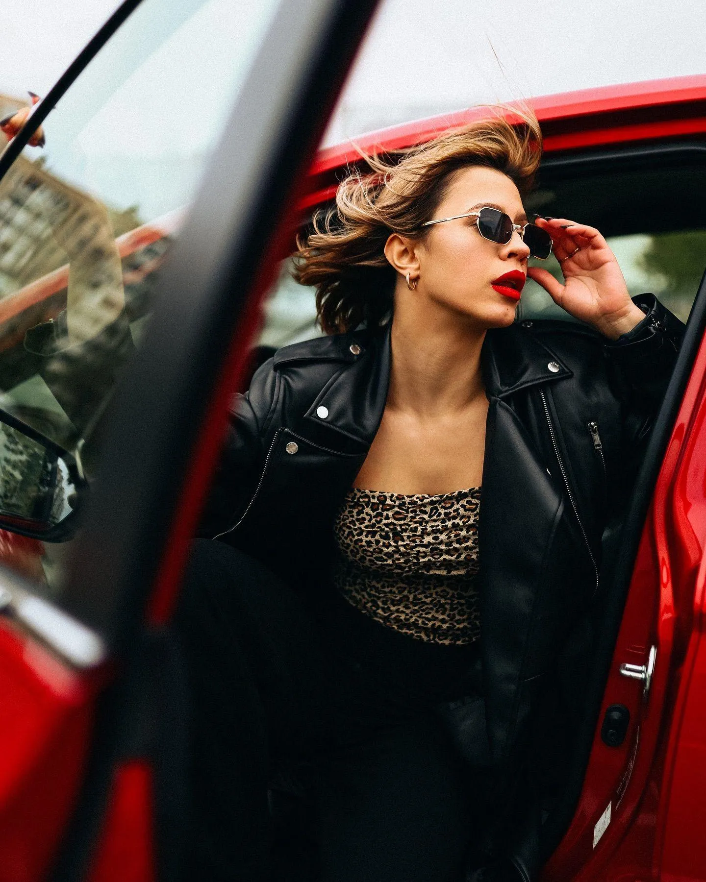 Confident Woman Stepping Out of Car in Leather Fashion Look