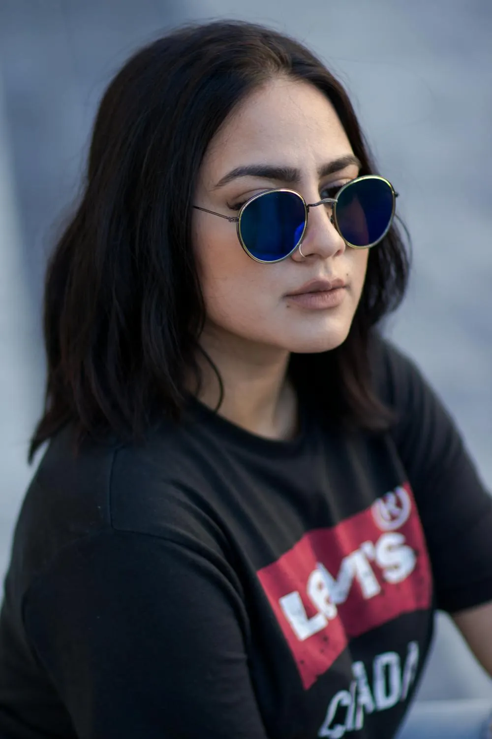 Confident Woman in Sunglasses Posing in a Black Tshirt Image