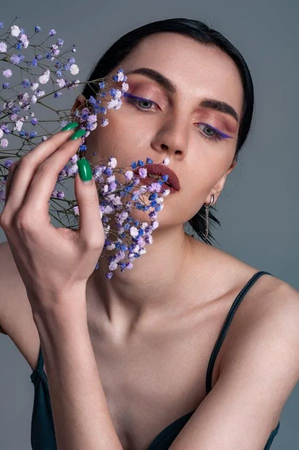 Creative Woman Holding Small Flowers Near Her Face Softly