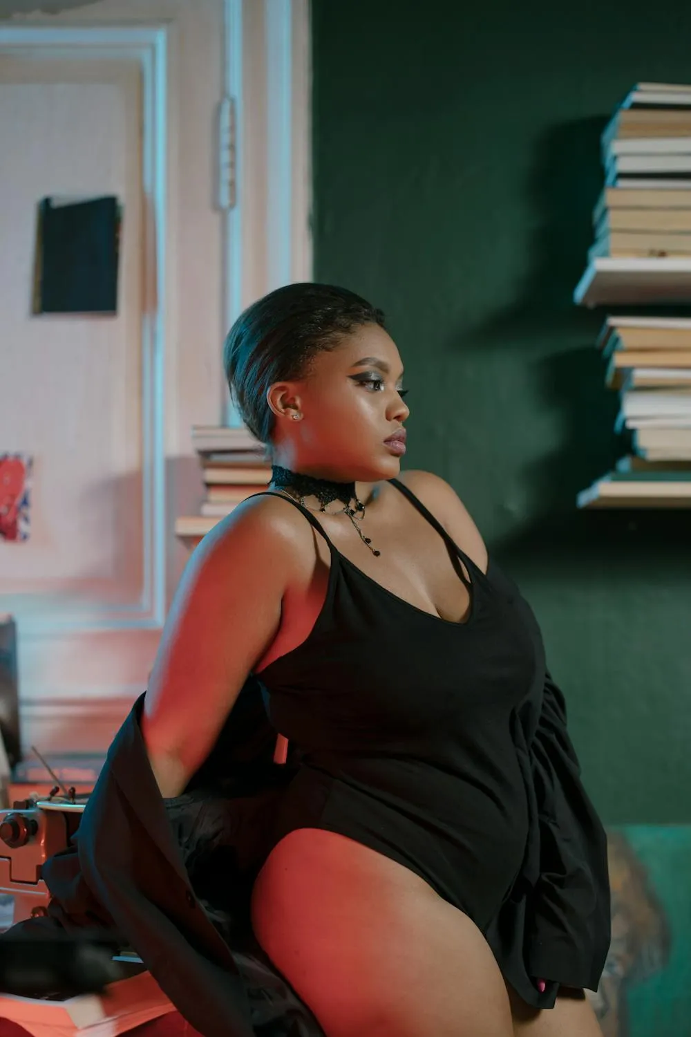 Curvy Woman Sitting on a Chair in a Confident Black Outfit