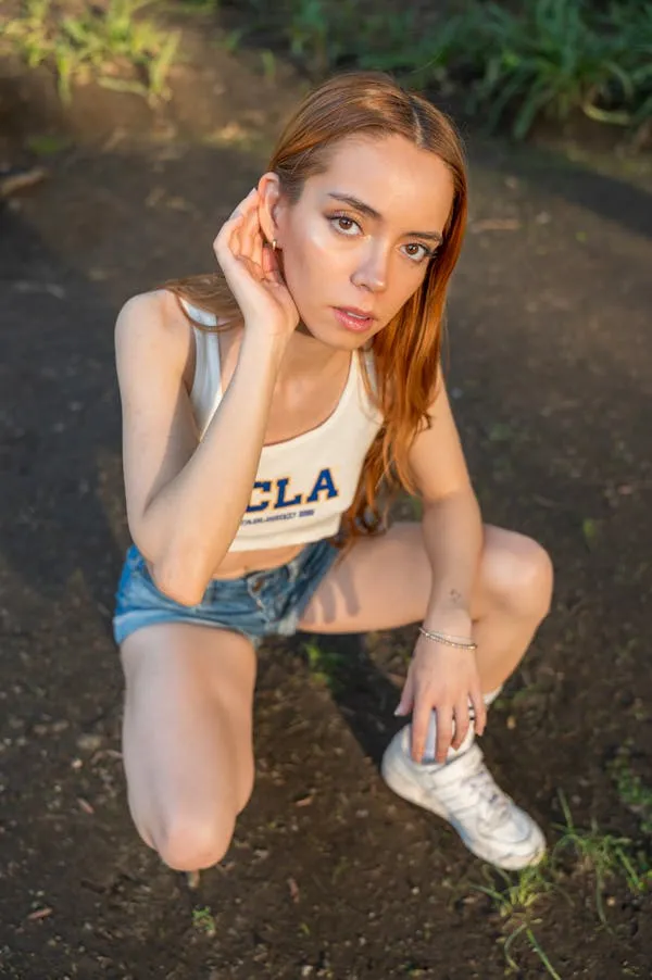 Cute Woman Crouching Outdoors Wearing Casual Sportswear