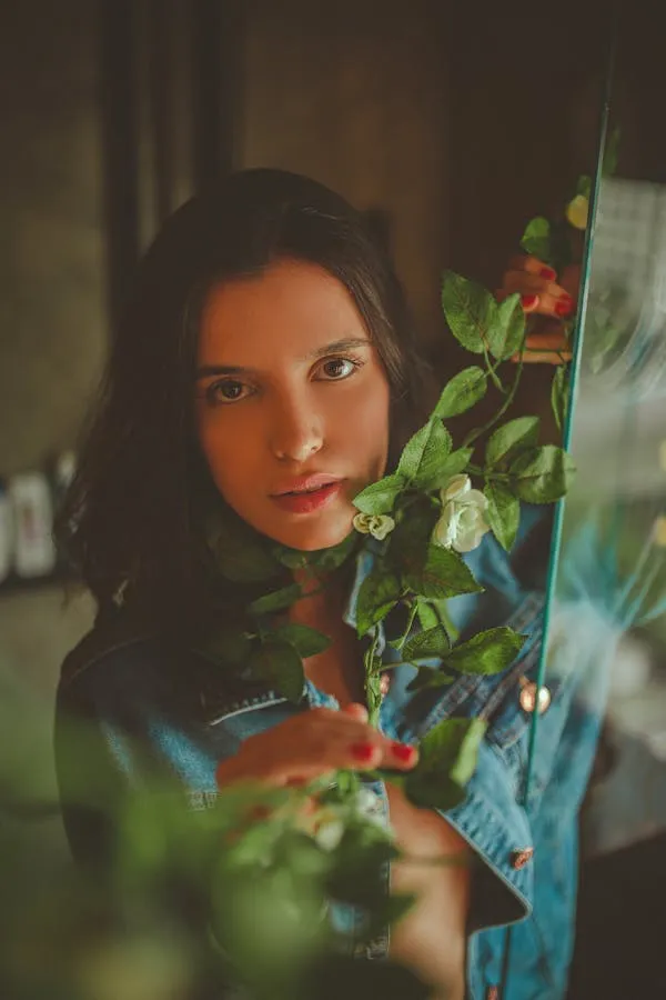 Cute Woman with Long Hair Posing with Plants in Soft Light