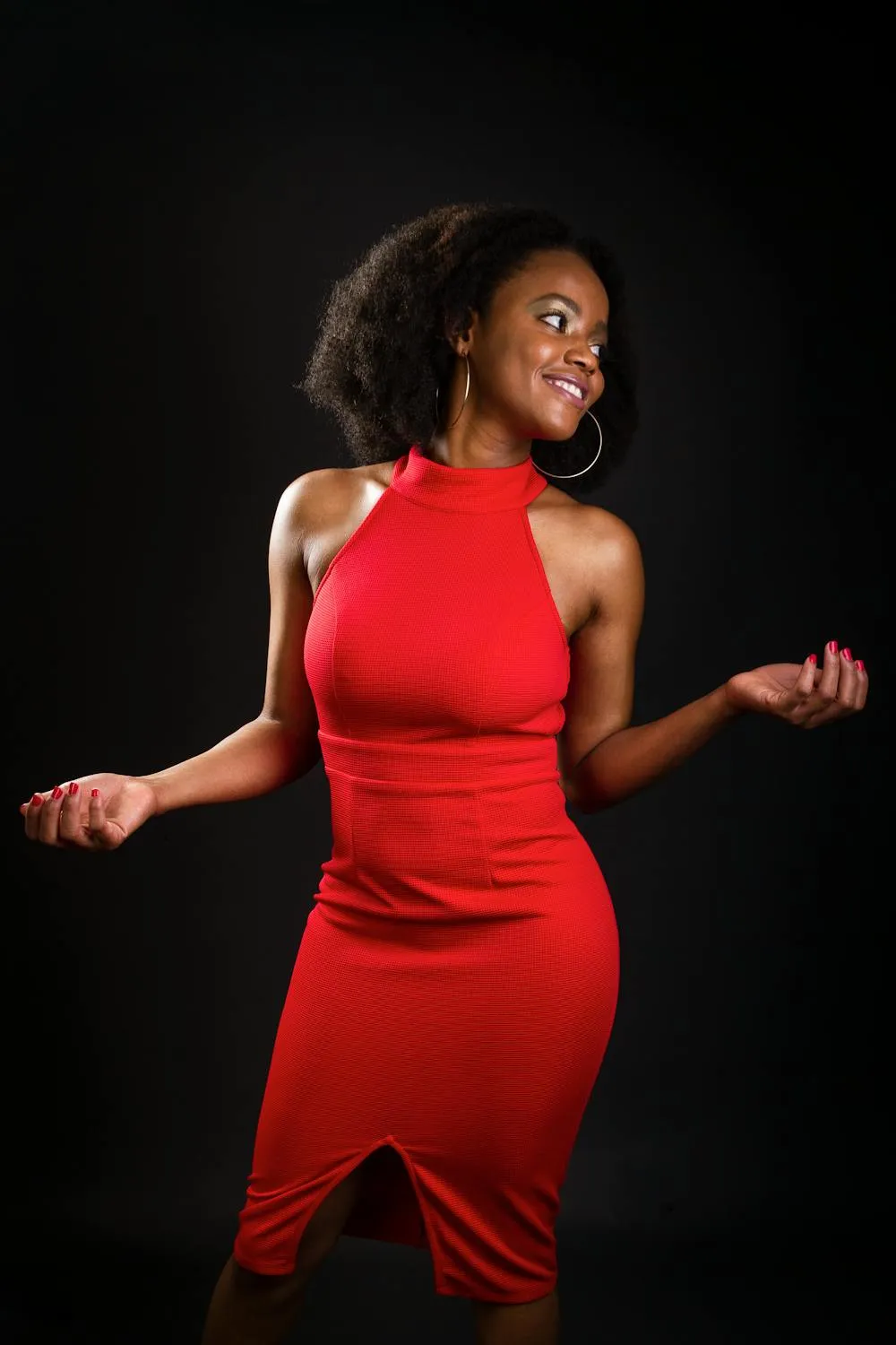 Cute Woman in a Red Dress Posing Against a Black Background