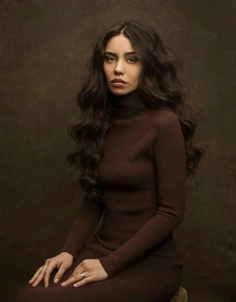Elegant Woman with Curly Hair Posing in a Brown Outfit Image