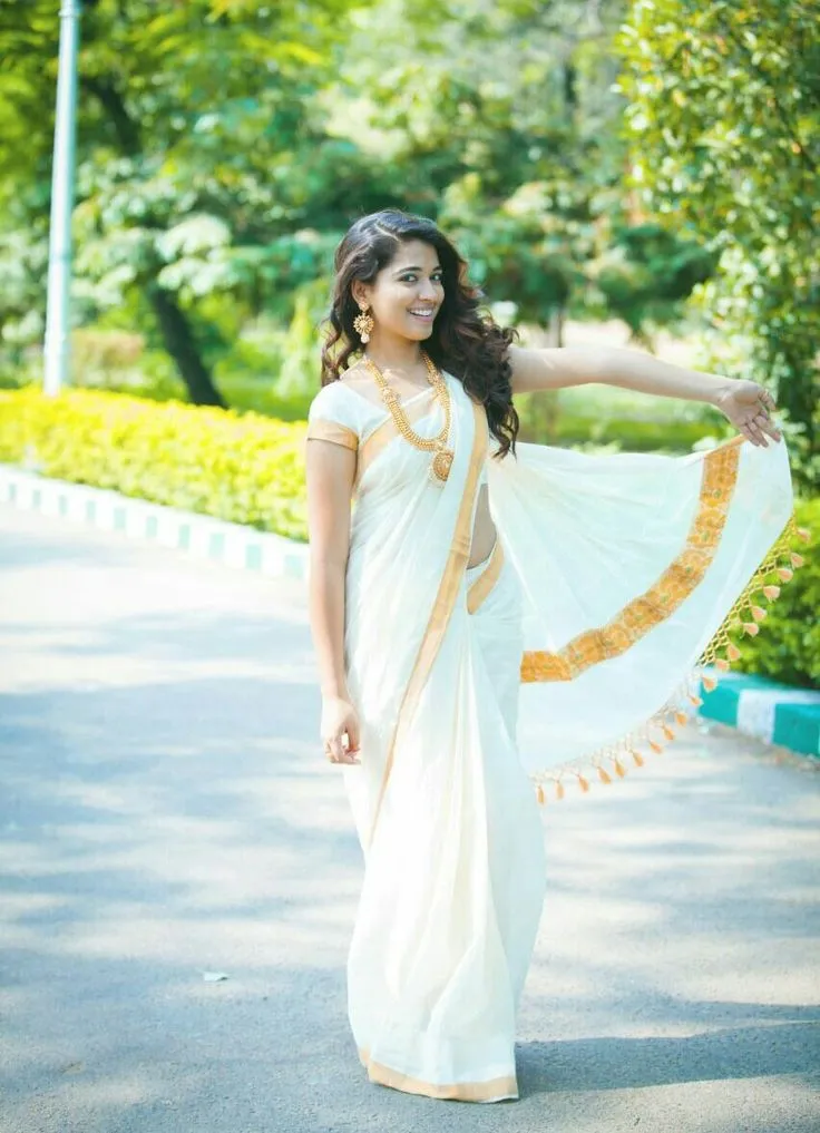Elegant woman in a white nerial saree standing on the road